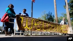 FILE - Supporters place a sign welcoming Syrian refugees at the entrance to the Arizona governor's office during a rally at the Capitol in Phoenix, Nov. 17, 2015.
