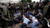 Militares venezolanos rodean a un grupo de estudiantes y manifestantes opositores detenidos el 14 de mayo de 2014 en Caracas. Un fiscal en Argentina imputó este jueves a comandantes y miembros de la Guardia Nacional Bolivariana venezolana por esas represiones.