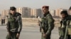 FILE - Members of the Kurdish-led Syrian Democratic Forces stand along a street, after rebels seized the capital and ousted Syria's Bashar al-Assad, in Hasakah, Syria, Dec. 11, 2024.