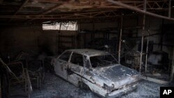 Foto de un automóvil consumido por las llamas tras un incendio forestal en Fyli, un sububio al noroeste de Atenas, Grecia, el 25 de agosto de 2023.
