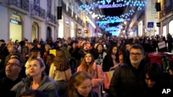 Varias personas contemplan las luces de Navidad en el barrio de Chiado, en el centro de Lisboa, Portugal, el sábado 23 de diciembre de 2023.