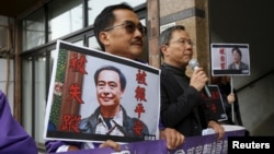FILE - Pro-democracy Civic Party protesters carry portraits of missing booksellers Lee Bo, left, and Gui Minhai outside the Chinese Liaison Office in Hong Kong, Jan. 19, 2016. Lee Bo returned to his home on March 24, 2016.