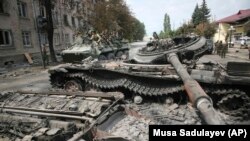 GEORGIA -- Russian soldiers ride atop an armoured vehicle through a street in Tskhinvali, capital of Georgian breakaway enclave of South Ossetia, August 12, 2008