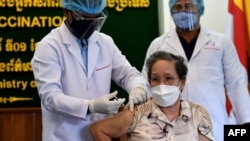 An official from the Ministry of Information is inoculated with a dose of China's Sinovac Covid-19 coronavirus vaccine at the Ministry of Information in Phnom Penh on April 1, 2021. (Photo by TANG CHHIN Sothy / AFP)
