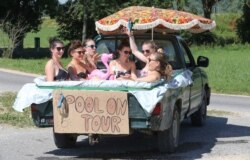 Six women cool themselves in water in a pick-up truck, which they sealed with a plastic sheet, in Unlingen, southern Germany, June 30, 2019.