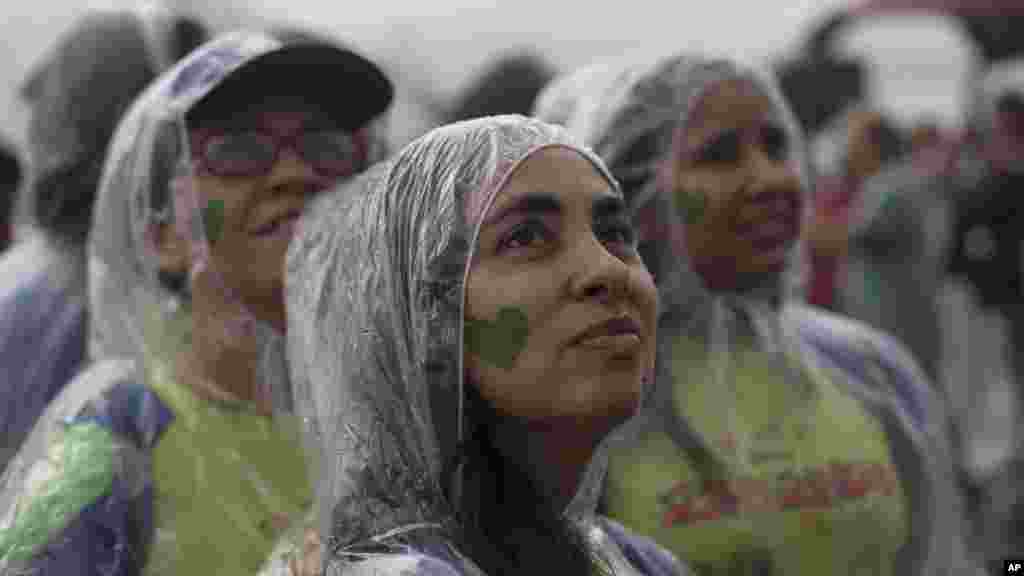 People with a green heart painted on their faces attend the People's Climate March in the rain at Ipanema beach, Rio de Janeiro, Brazil, Sept. 21, 2014. 