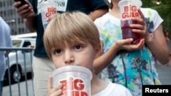 Benjamin, 8, minum soda berukuran besar saat ikut serta dengan ayahnya dalam protes terhadap larangan penjualan soda berukuran besar di New York. (Foto: Dok)