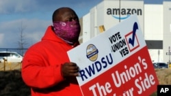 Michael Foster, seorang karyawan Amazon.com, memegang poster di luar gedung Amazon di mana para pekerja berusaha mengorganisasi pembentukan serikat pekerja di Bessemer, Alabama, 9 Februari 2021. 