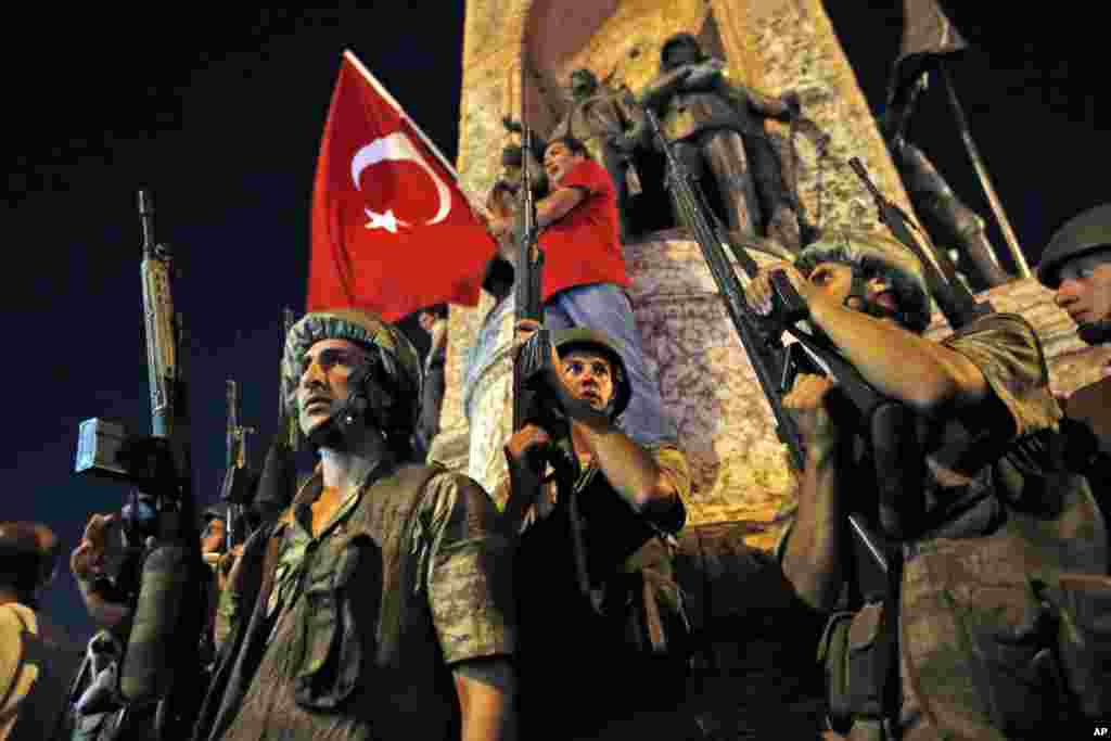 Turkish soldiers secure the area as supporters of Turkey's President Recep Tayyip Erdogan protest in Istanbul's Taksim square, early Saturday, July 16, 2016.