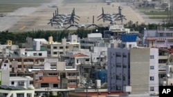 FILE - MV-22 Ospreys are seen at the U.S. Marine Corps Futenma Air Station and the surrounding area from an observation deck at a park in Ginowan, Okinawa Prefecture, Japan.