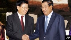 Cambodia's Prime Minister Hun Sen, right, shakes hands with his Laos Prime Minister Thongloun Sisoulith as they meet at Peace Palace, in Phnom Penh, Cambodia, Monday, June 27, 2016. Thongloun is on an official visit to Cambodia to further expand and strengthen the existing traditional relations of friendship, good neighborliness, and comprehensive cooperation between the two countries, according to a release. (AP Photo/Heng Sinith)