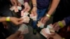Turistas muestran los billetes viejos de bolívares para usarlos como tiques para intercambiarlos por comida en un tour realizado en Caracas, Venezuela, el 21 de agosto de 2021. La inflación entre enero y junio fue de 100 puntos, según una organización no gubernamental.