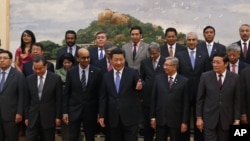 Chinese President Xi Jinping, center, shows the way to the guests who attended the signing ceremony of the Asian Infrastructure Investment Bank at the Great Hall of the People in Beijing, Oct. 24, 2014.