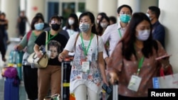 Passengers wearing medical masks walk as they arrive at international arrival terminal of I Gusti Ngurah Rai airport following an outbreak of the new coronavirus in China, in Bali, Indonesia, February 4, 2020. Picture taken February 4, 2020. REUTERS…