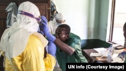 Des agents de santé s’entraident à porter les équipements de protection contre Ebola à Mbandaka, Equateur, RDC, 17 mai 2018. (Twitter/ONU Info)