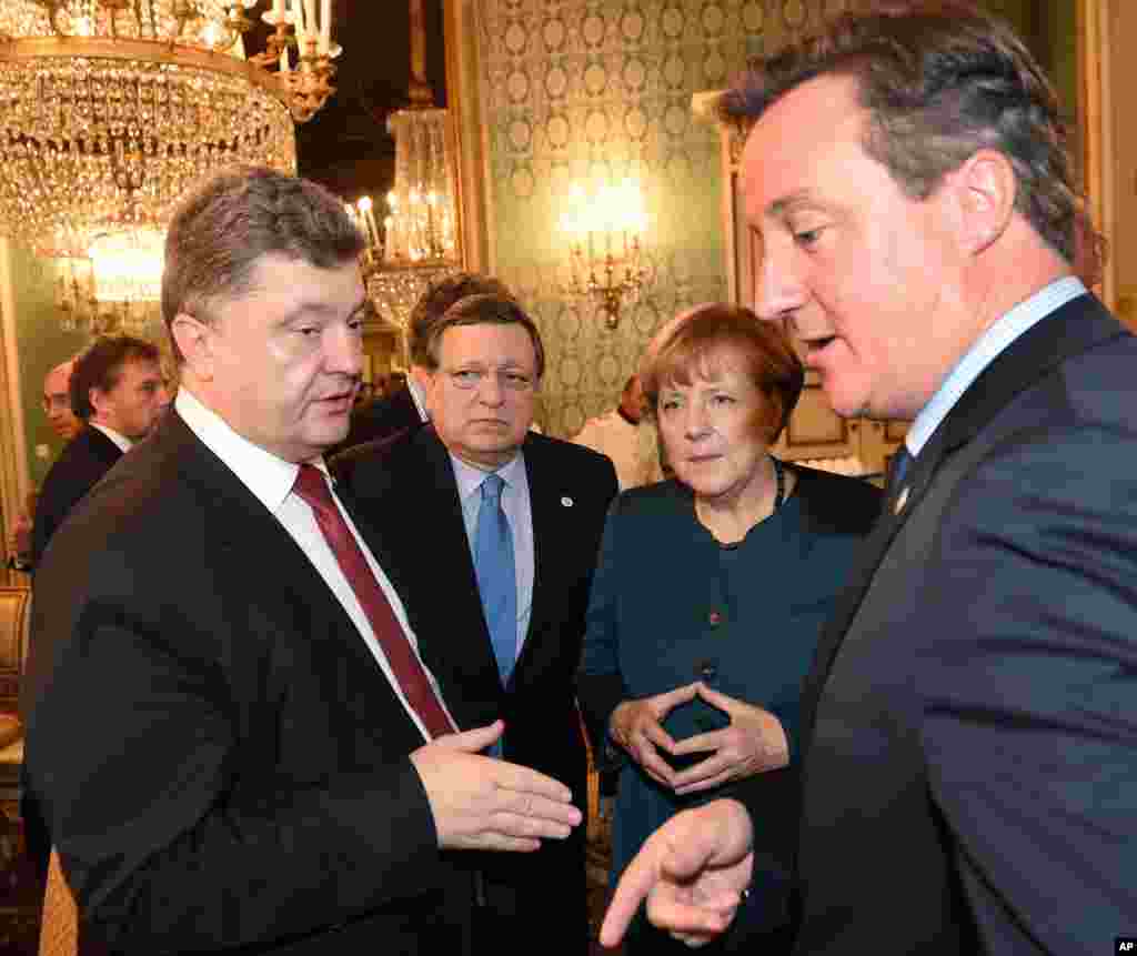 From left, Ukraine's President Petro Poroshenko, EU Commission President Jose Manuel Barroso, German Chancellor Angela Merkel and British Prime Minister David Cameron meet on the sidelines of the ASEM summit of European and Asian leaders in Milan, Oct. 17, 2014.