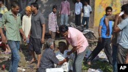 Seorang pria cedera, dan keluarganya tewas, menangis di lokasi ledakan, di Petlawad, negara bagian India, Madhya Pradesh, 12 September 2015. 