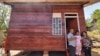 Enos Marajani bersama anggota keluarganya berfoto di depan huntara individual yang disebut sebagai rumah tumbuh di desa Sungku, Kecamatan Kulawi, Kabupaten Sigi, Sulawesi Tengah. (Foto : Dewi Sri Sumanah/Save the Children Indonesia)