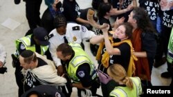 Policija privodi demonstrante tokom protesta u zgradi američkog Kongresa (REUTERS/Jonathan Ernst)