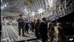Terlihat pengungsi Afghanistan memasuki pesawat angkut militer AS saat evakuasi di Bandara Internasional Hamid Karzai di Kabul, Afghanistan, 22 Agustus 2021. (Foto: via AP)