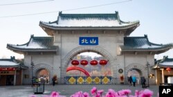 Turis berjalan melewati gerbang yang disebut "Beishan" di Taman Beishan di provinsi Jilin, China, pada 23 Januari 2020. (Foto: Zhu Wanchang/CNS Photos via AP)