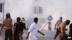 Riot police fire tear gas Friday, Sept. 16, 2011, in Sitra, Bahrain.