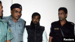FILE - Police guard Mufti Abdul Hannan (2nd R), alleged leader of the Bangladesh chapter of the Islamist militant group Harkatul Jihad, outside a court in Dhaka, October 2, 2005.