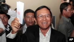 Opposition Cambodia National Rescue Party President Kem Sokha shows off his ballot before voting in local elections in Chak Angre Leu on the outskirts of Phnom Penh, Cambodia, Sunday, June 4, 2017. Cambodians are voting in local elections that could shake