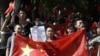 资料照片：2012年9月14日星期五，中国北京的反日抗议进入第四天，中国抗议者举着中国国旗和写着“日本狗，战败国”的纸游行到日本大使馆。