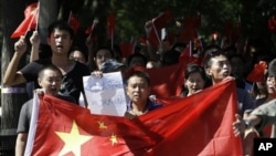 中国抗议者2012年9月14日举着反日标语在日本驻北京使馆前连续第四天示威。 