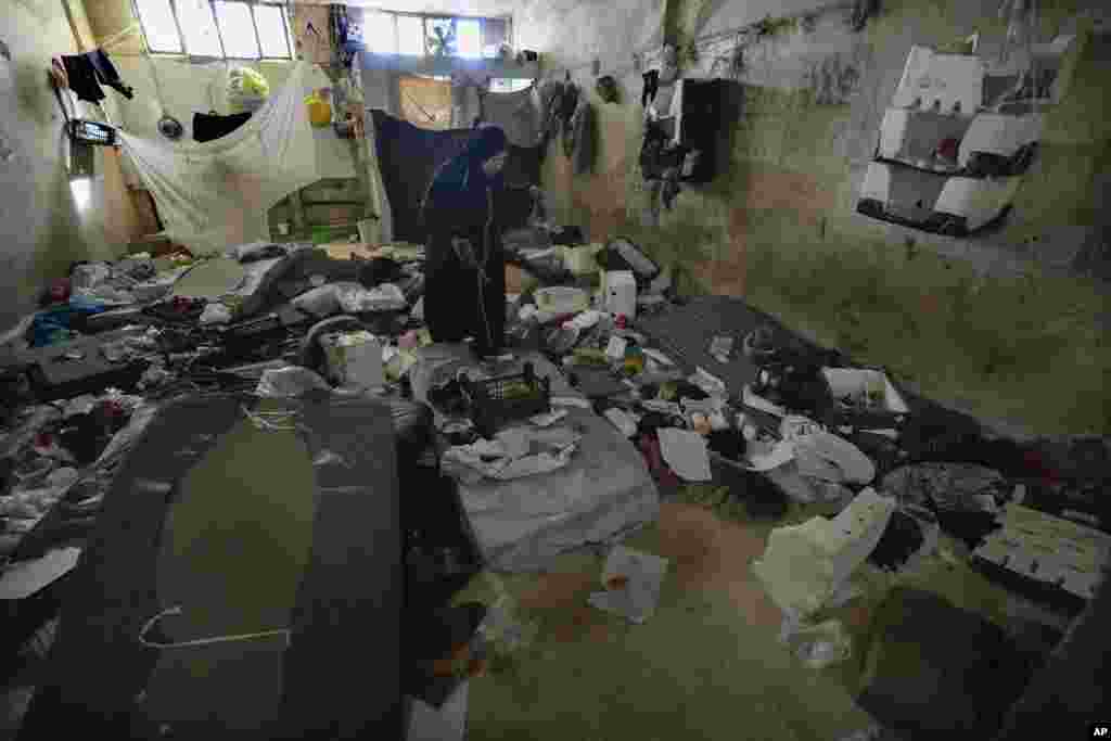 A woman looks at a room of the infamous Saydnaya military prison, just north of Damascus, Syria, Dec. 9, 2024. 