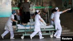 Petugas medis membawa korban ledakan pabrik di sebuah rumah sakit di Kunshan, provinsi Jiangsu, 2 Agustus 2014.