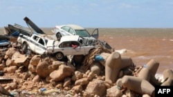 Magari yamerundikana juu ya vifusi vya jengo lililoharibiwa na mafuriko baada ya dhoruba ya Mediterania "Daniel" kupiga mji wa mashariki mwa Libya wa Derna, Septemba 14, 2023.
