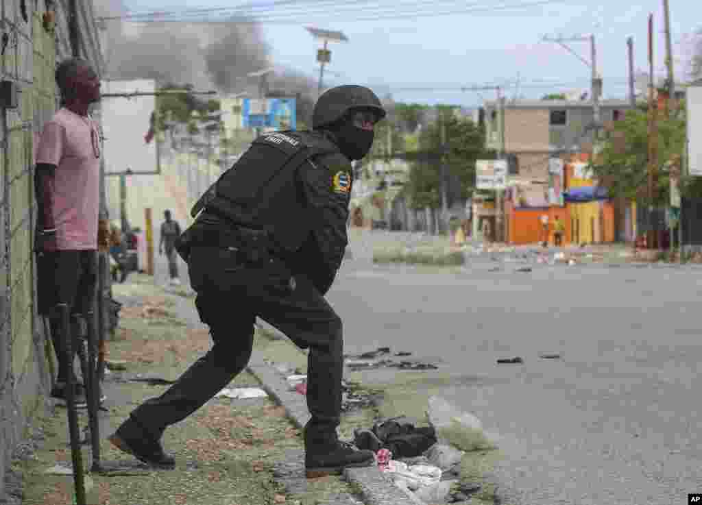 Un policía se alista a intervenir durante un tiroteo entre pandillas y policías en Puerto Príncipe. 