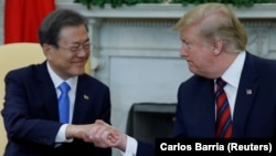 美国总统特朗普和韩国总统文在寅在白宫椭圆形办公室握手。(2019年4月11日)