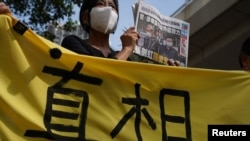 Un partidario sostiene una copia del periódico Apple Daily durante una audiencia judicial frente a los magistrados, después de que la policía acusara a dos ejecutivos del periódico pro democrático Apple Daily bajo la ley de seguridad nacional.