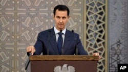 FILE - In a photo released by the official Facebook page of the Syrian Presidency, Syrian President Bashar al-Assad speaks to Syrian diplomats, in Damascus, Syria, Aug. 20, 2017.