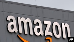 FILE - A sign is lit on the facade of an Amazon fulfillment center, Thursday, March 19, 2020, on Staten Island in New York. 