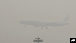 Avion Er Čajna sprema se da sleti na međunarodni aerodrom u Pekingu kroz oblak smoga