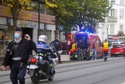 French policemen and firemen stand next to Notre Dame church after a knife attack, in Nice, France, Oct. 29, 2020.