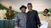 Nigeria's President Goodluck Jonathan, center-left, and opposition candidate Gen. Muhammadu Buhari, center-right, hug and shake hands after signing a renewal of their pledge to hold peaceful "free, fair, and credible" elections, at a hotel in Abuja.