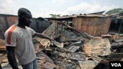 Seorang pria menunjukkan reruntuhan sebuah toko akibat bentrokan pasukan Pantai Gading dan pejuang pro-Outtara di Abidjan, Rabu (16/3).