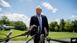 President Donald Trump listens to a question from a member of the media on the South Lawn of the White House in Washington, May 14, 2019.
