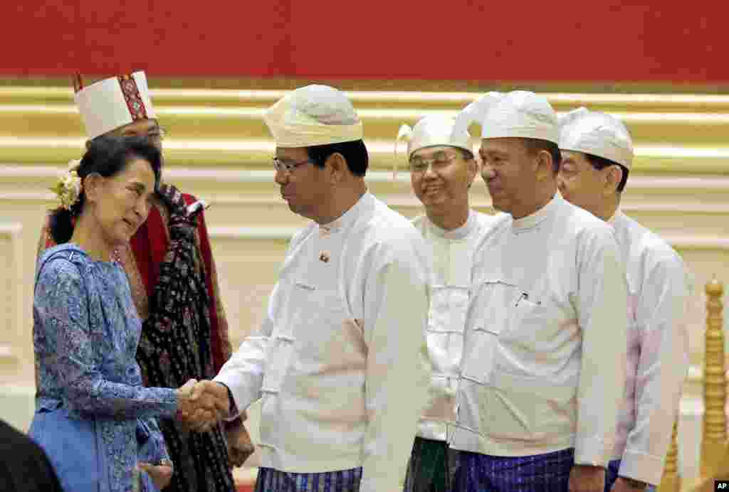 Aung San Suu Kyi, left, greets members of Myanmar's old cabinet during a presidential handover ceremony in Naypyitaw.