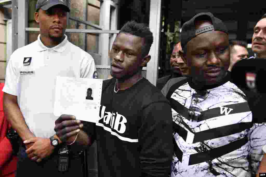  Mamoudou Gassama dan asalin kasar Mali tare da yayan sa a lokacin da yake rike da takardar izinin zama a kasar Faransa da ya samu a ranar 29 ga watan Mayu.