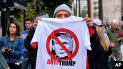 FILE - A street vendor sells an anti-President Trump T-shirt during a protest outside Los Angeles City Hall, in Los Angeles, California, Feb. 20, 2017.