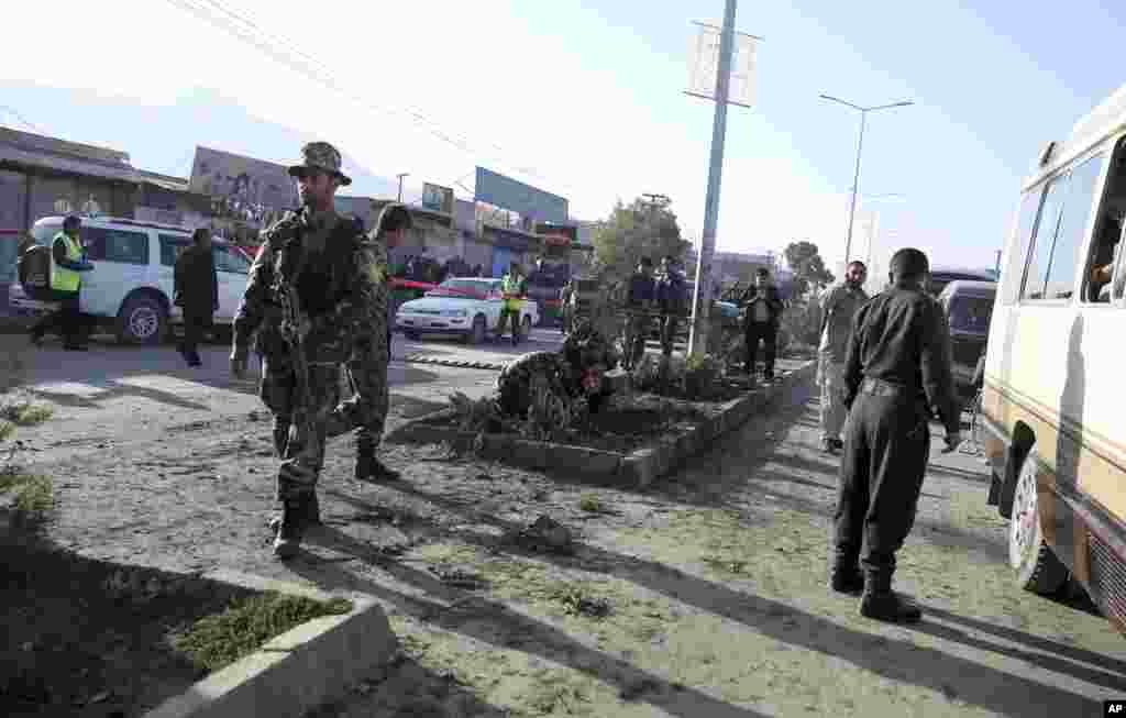 Afghan security forces inspect the site of a roadside bomb explosion which destroyed a mini bus, in Kabul, Afghanistan, Oct. 21, 2014.