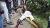 IA injured men lies on the ground after clashed with police at a market in the Abobo neighborhood in Abidjan, October 15, 2012.