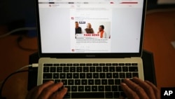 FILE - A man browses through the Twitter account of Alt News, a fact-checking website, April 2, 2019.