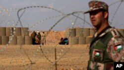 FILE - In this Feb. 14, 2017 photo, a Jordanian soldier stands guard at the northeastern border with Syria, close to the informal Rukban camp for displaced Syrians.